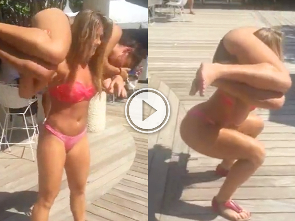 A strong woman in pink lingerie holds a man high in her hands and does squats with him