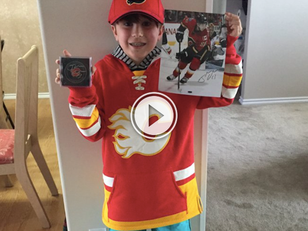 Kid in red jersey holds the poster of his favorite ice hockey player!
