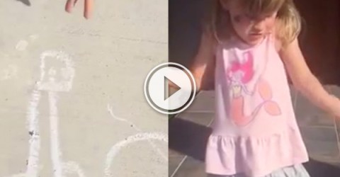 A chalk drawing on concrete and a little girl in grey skirt and pink top!