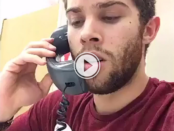 Dude in burgundy tee talking on a landline!