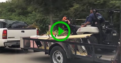 Dude rides on mower hitched to back of truck (Video)